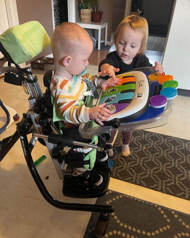 Two young children sharing a toy at the table