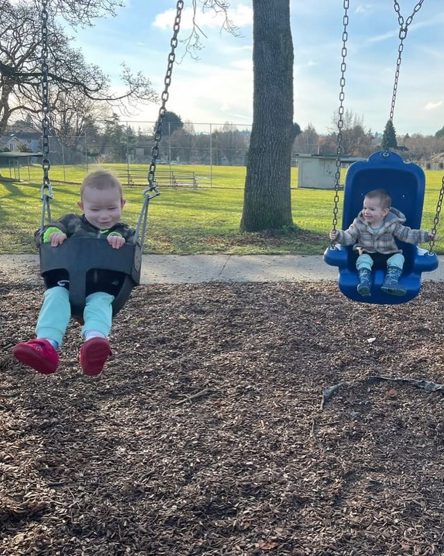 Two children enjoying the swings at a neighbourhood park